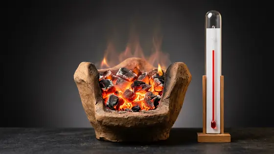 चूल्हे में जलता कोयला, पास में थर्मामीटर